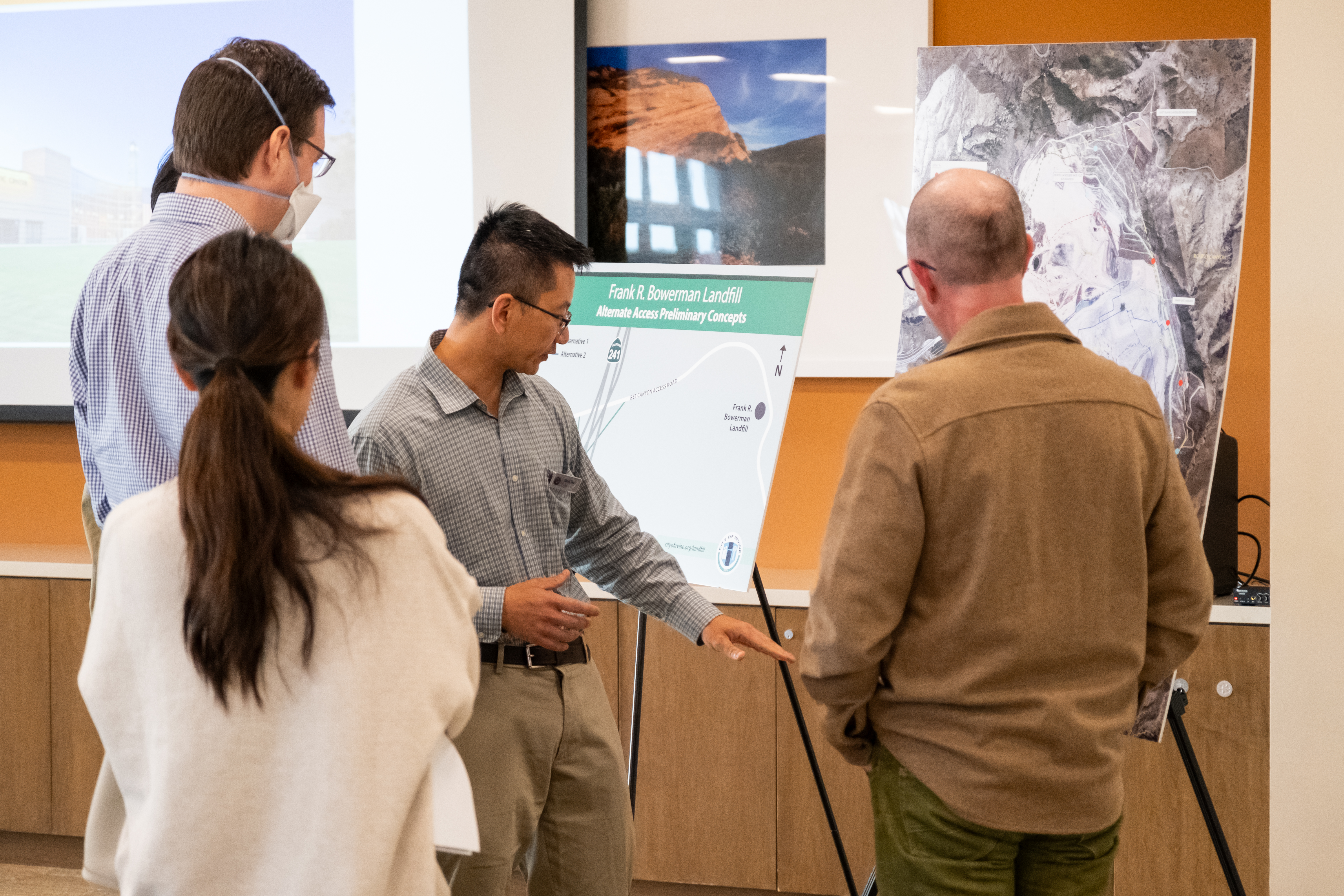 Men and women standing in front of poster boards with maps of the Bowerman Landfill 