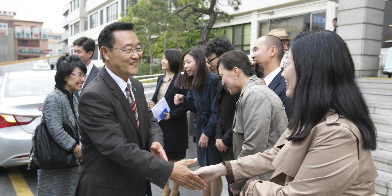 Group of people smiling and shaking hands outside