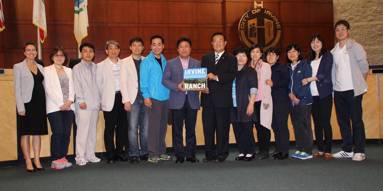 Photograph of smiling adults posing while being presented a book