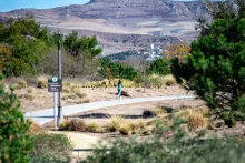 woman running down trail with landscape around