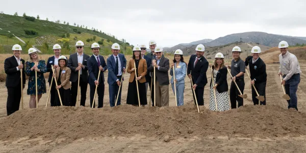 Groundbreaking ceremony with people in hard hats and shovels.