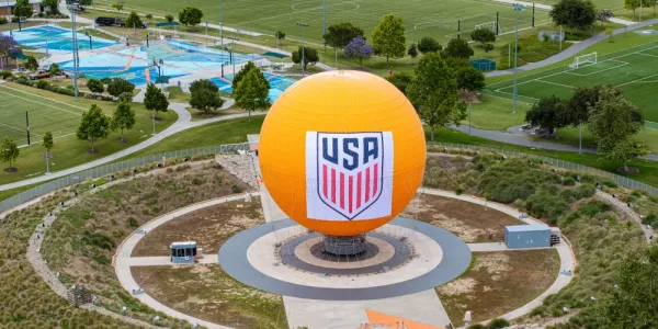 Large orange sphere with a USA logo in a recreational park.