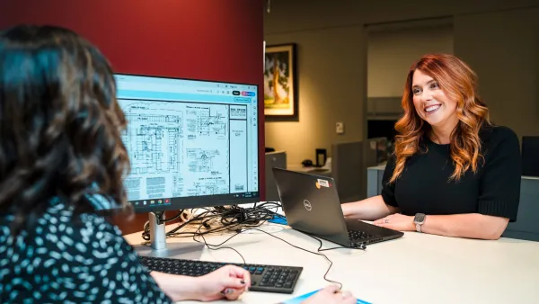 Two women at the development counter, one smiling at the other.