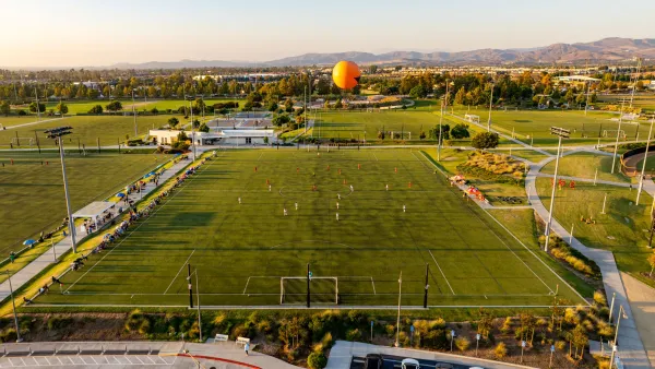 Golden hour aerial view of the Great Park Sports Complex with a soccer game underway and the Great Park Balloon.
