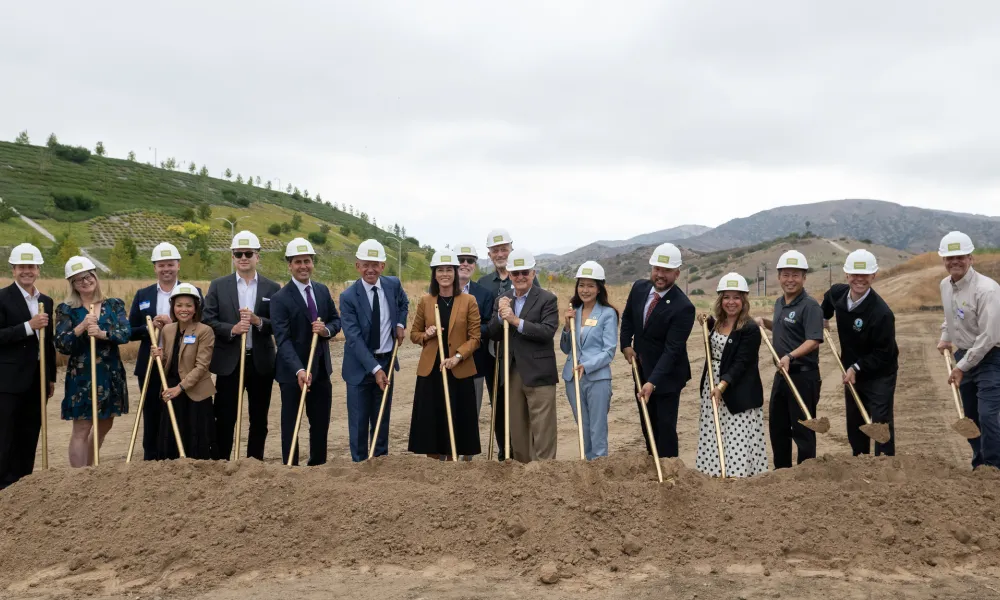Groundbreaking ceremony with people in hard hats and shovels.