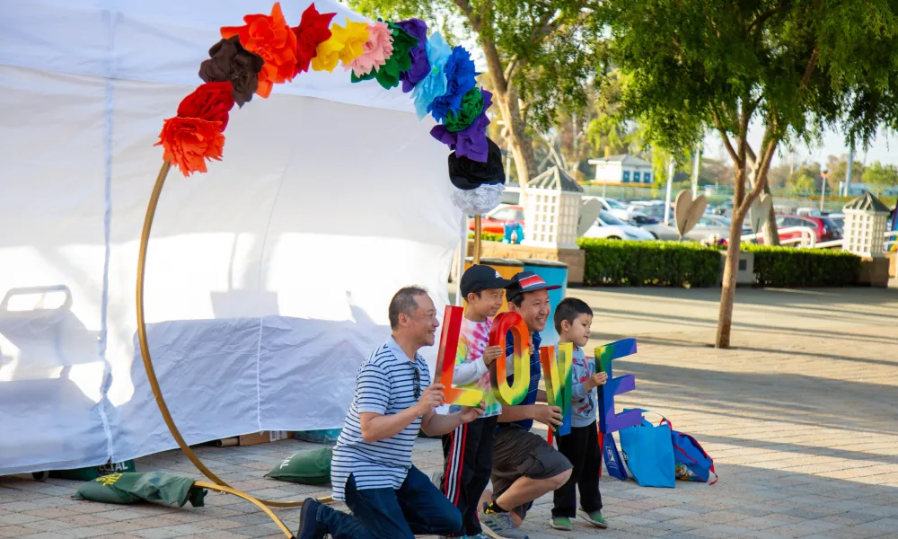 A family posing for a photo with a colorful backdrop
