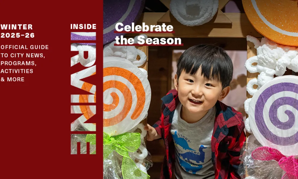 Young boy smiling amidst colorful oversized candy decorations.