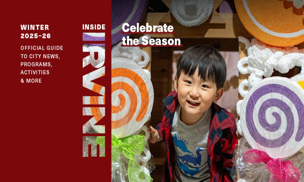 Young boy smiling amidst colorful oversized candy decorations.