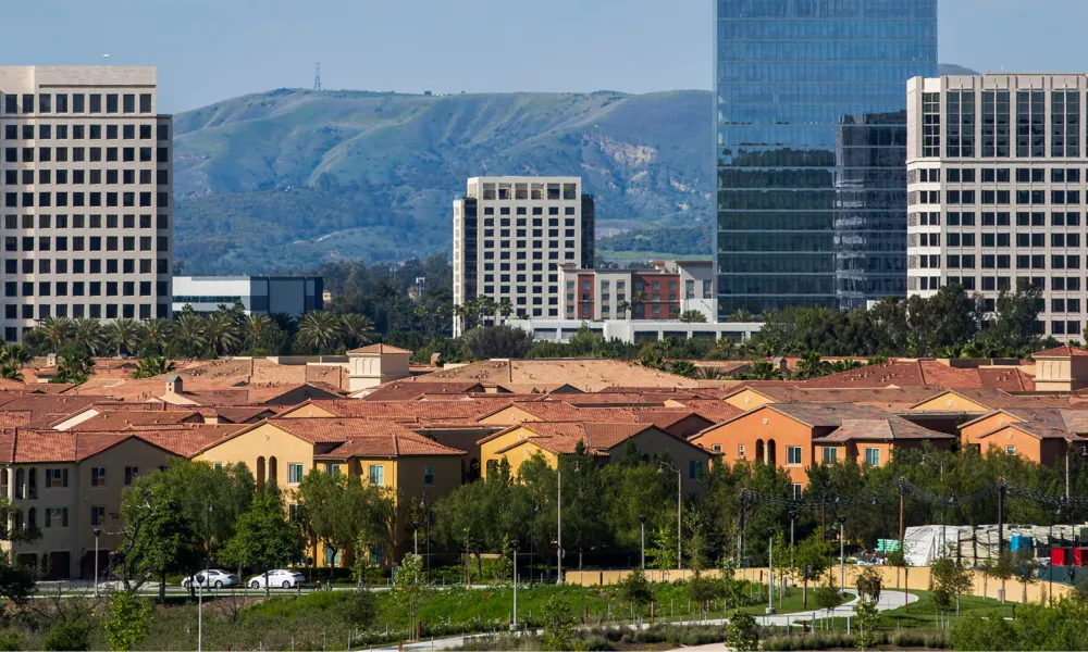 houses and office buildings with mountains in the background