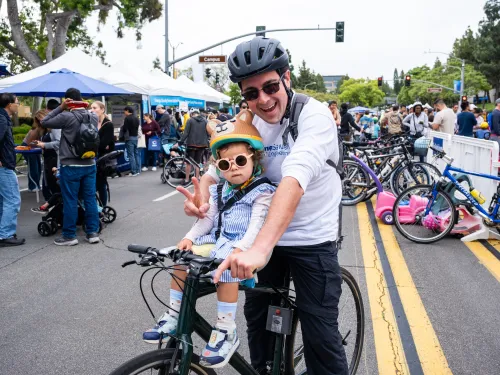 father and child on a bike wearing helmets