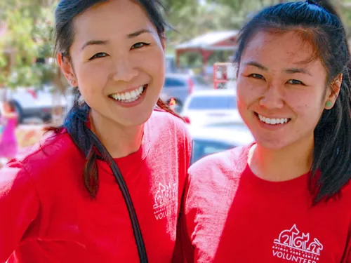 Two females wearing a red shirt and smiling
