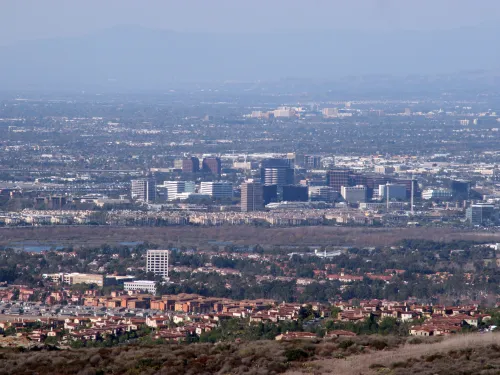 Distant city panorama with commercial towers, residential homes, and hazy hills.